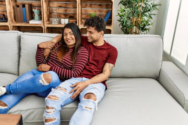 hispanic couple cuddling on the couch