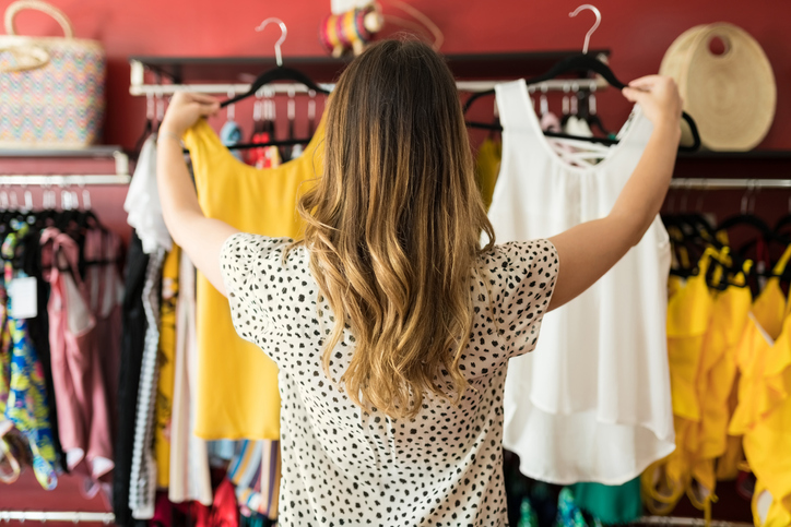 Trendy clothes hanging in a closet.