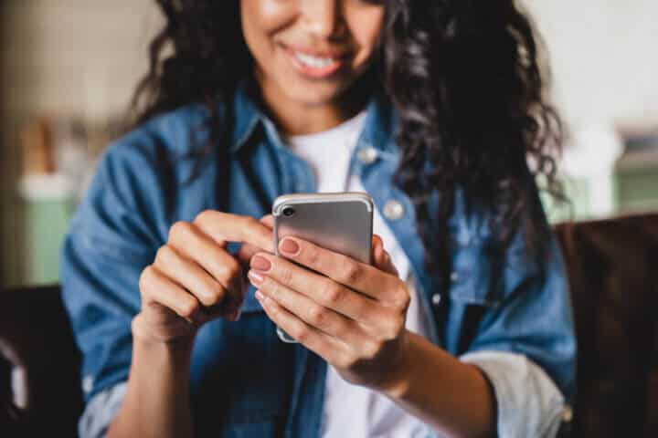 smiling woman texting on phone
