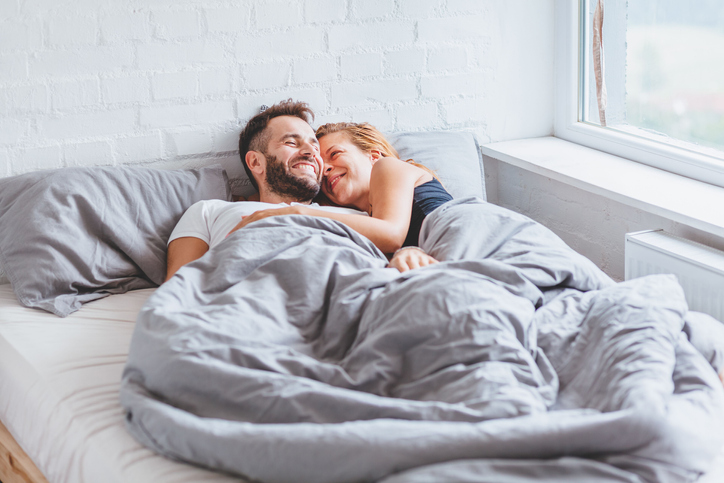 happy couple waking up in bed