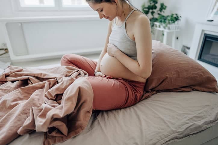 Young expectant mother stroking her baby bump.