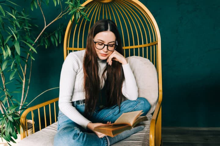 woman sitting in chair reading