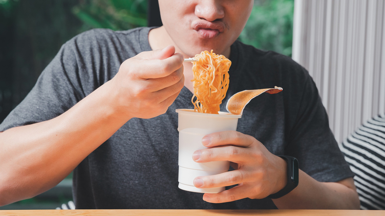 Man eating instant noodles.
