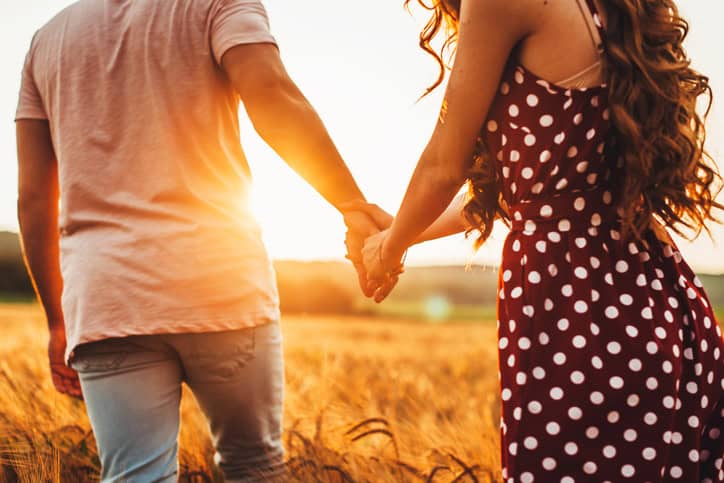 couple holding hands in the sunset