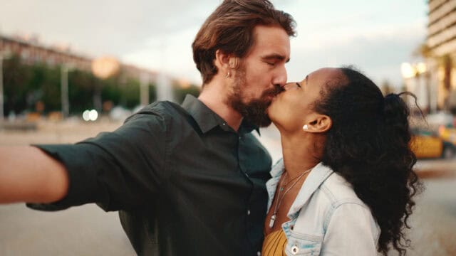 couple kissing in city selfie