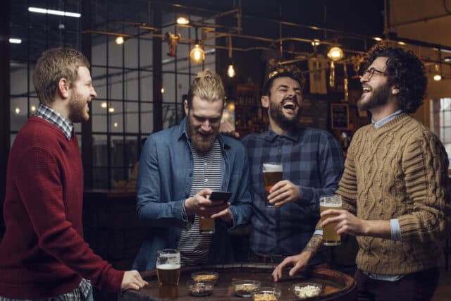 hipster guys drinking at bar
