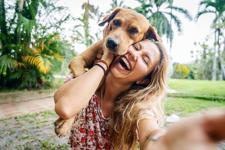 young woman laughing with her dog