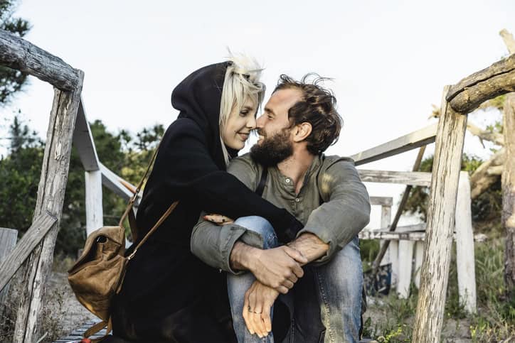 couple sitting on a bridge