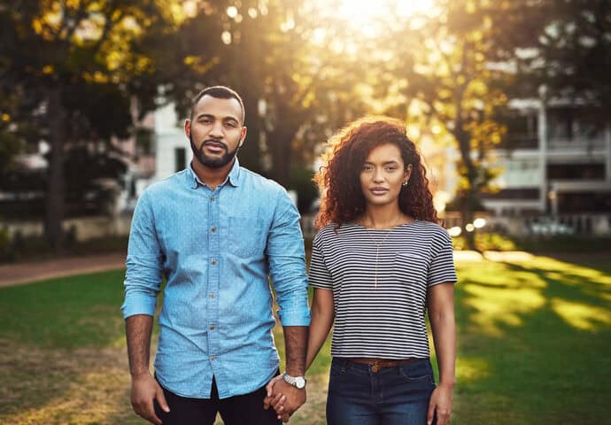 serious black couple holding hands outdoors