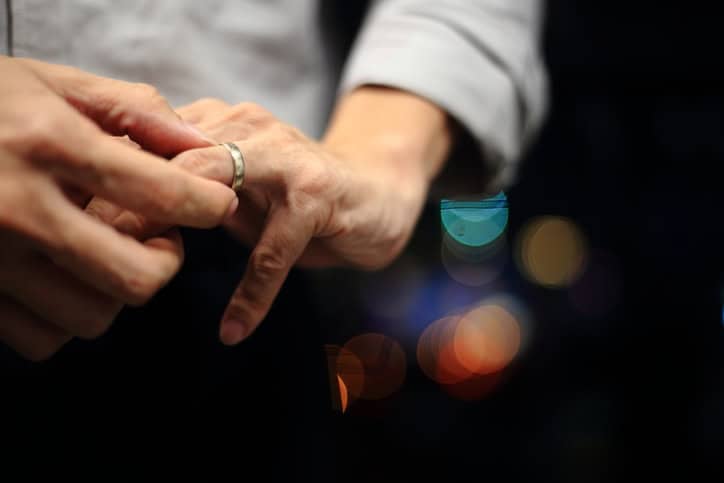 Man putting his wedding ring on.