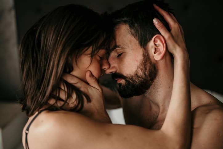 couple embracing naked in bed