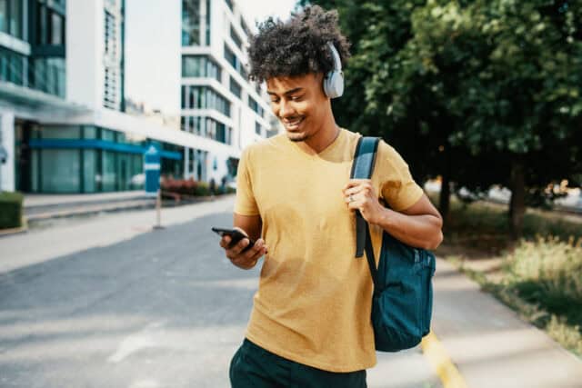 guy texting while walking outdoors