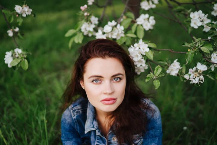 woman sitting down amongst greenery
