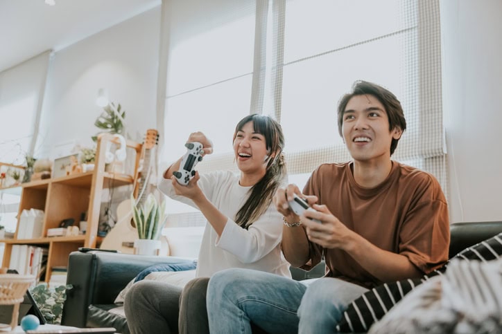 couple playing video games on couch