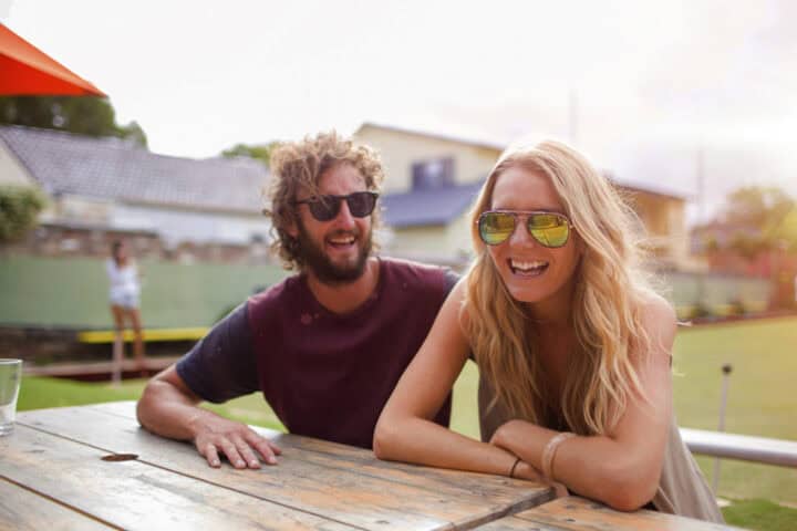 Couple laughing at an outdoor cafe.
