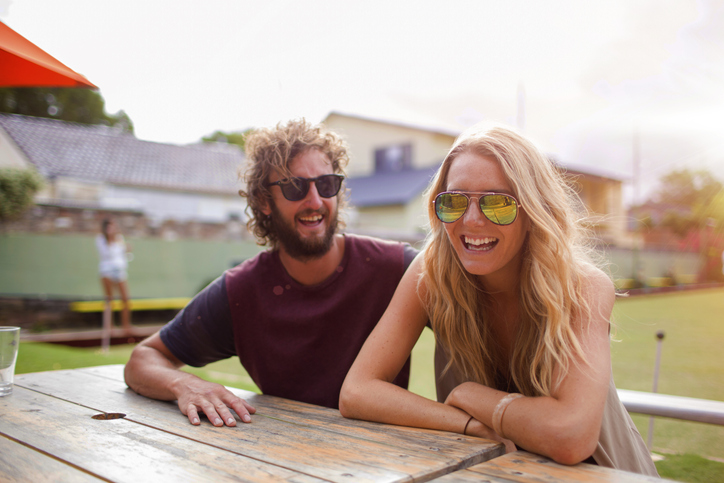 Couple laughing at an outdoor cafe.