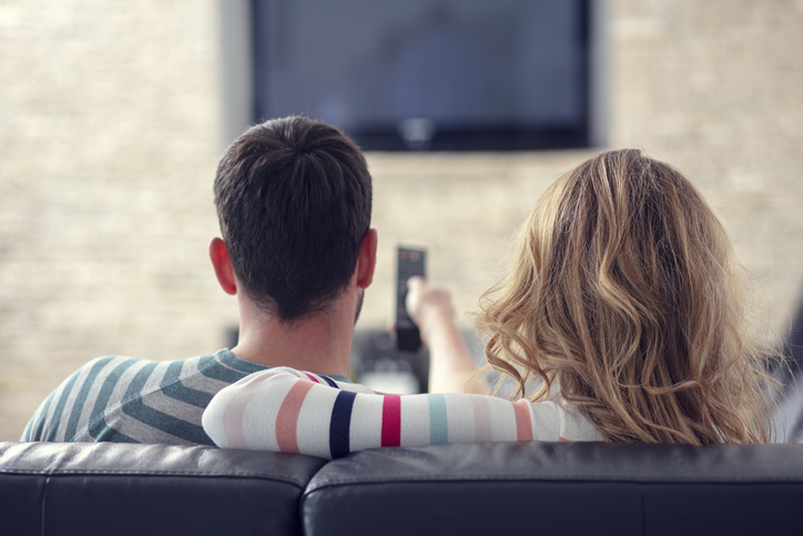 Couple relaxing and watching TV at home.
