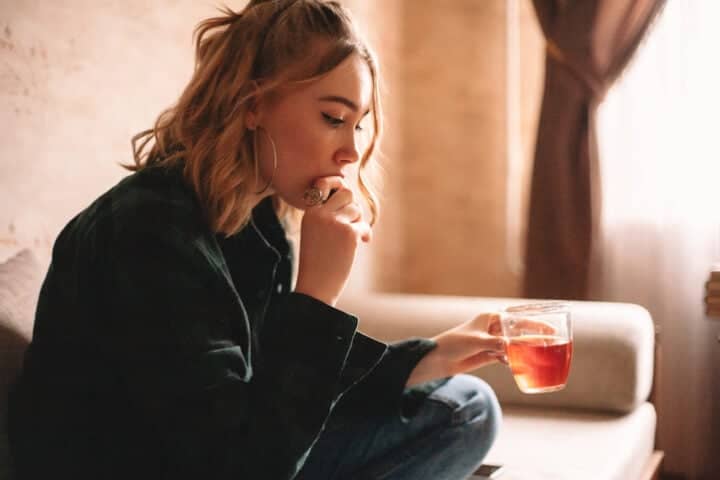 woman looking sad with cup of tea