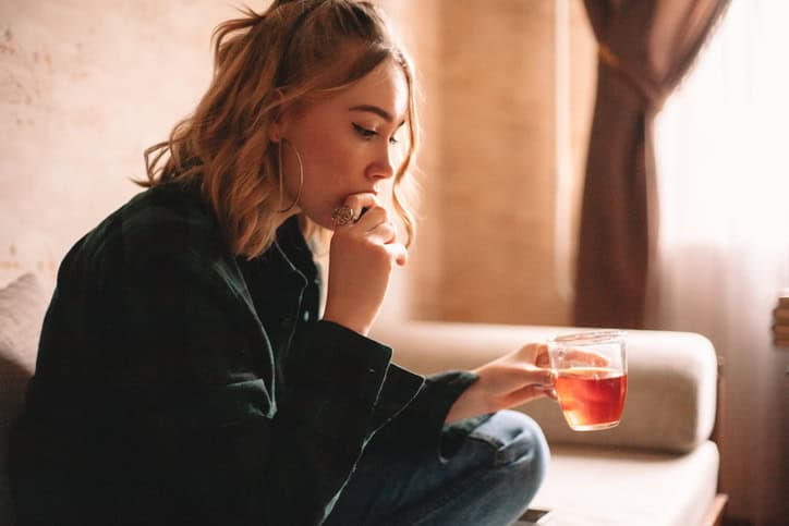 woman looking sad with cup of tea