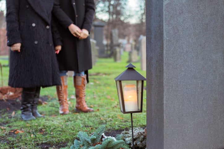 People standing at graveside.