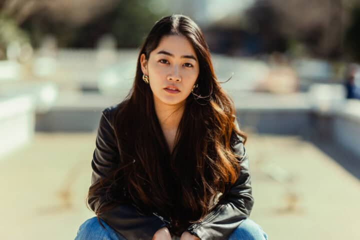 asian woman sitting black leather jacket