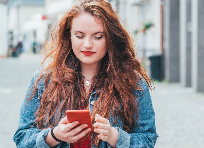 long haired redhead woman texting