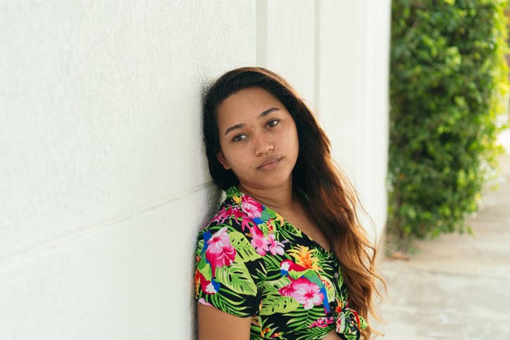 long haired woman standing by wall