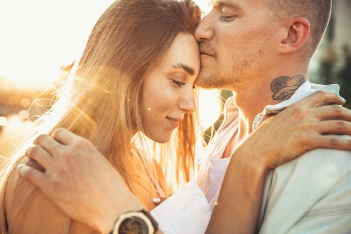 couple holding each other sunlight