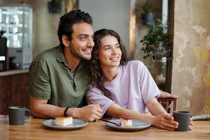young couple smiling near window