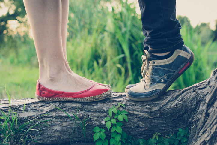 Shorter man on his tiptoes to reach woman.