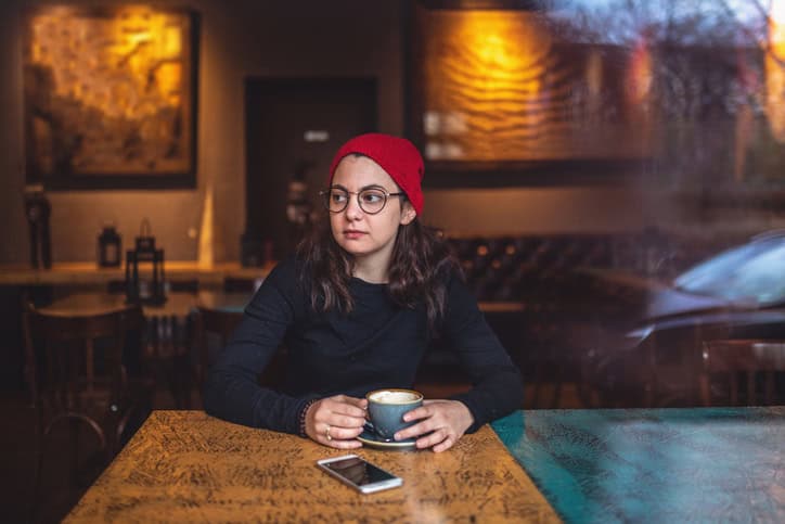 young woman sitting alone cafe