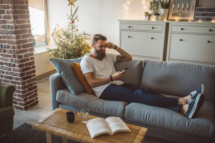 relaxed man texting on couch