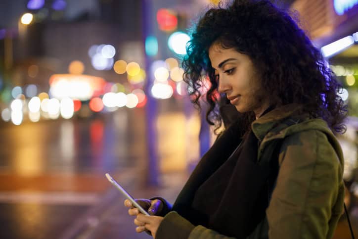 woman texting outdoors at night