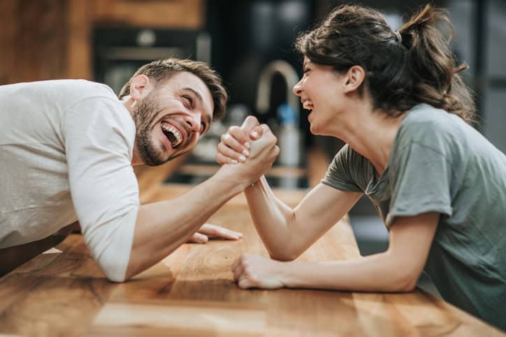 couple laughing while arm wrestling