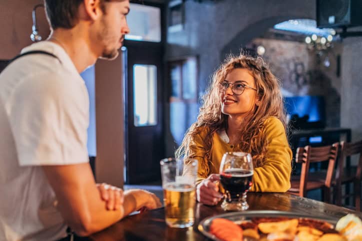 man and woman flirting at bar