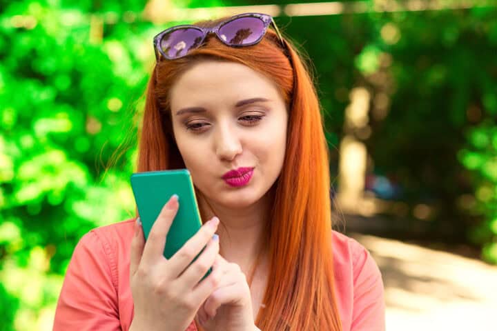 annoyed woman texting on smartphone