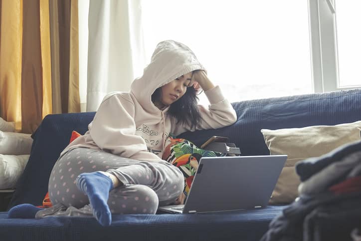 Woman in pajamas on couch.