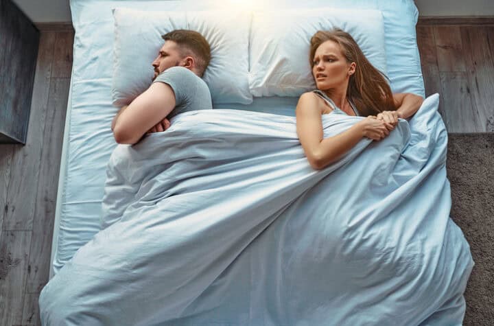 unhappy couple in bed