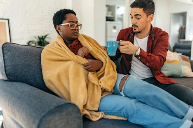 man offering unhappy girlfriend tea