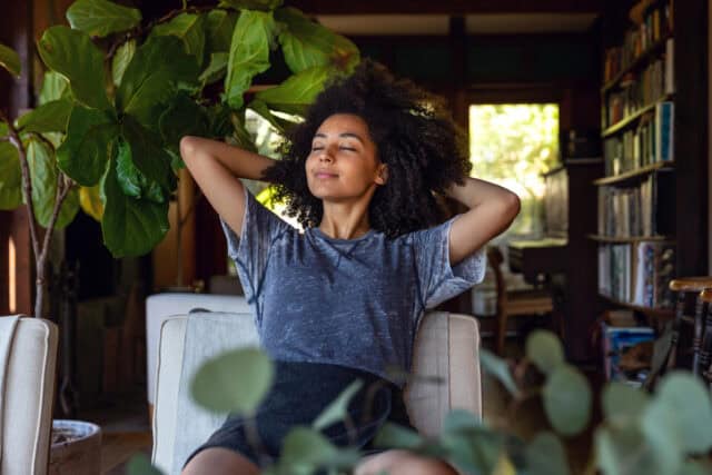 woman relaxing with eyes closed at home