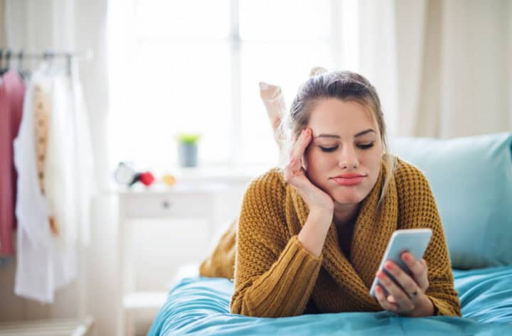 bored woman texting in bed