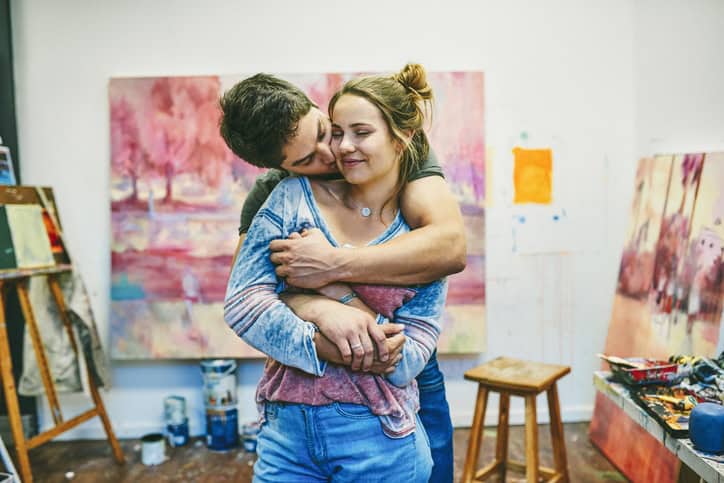 man embracing woman at art studio