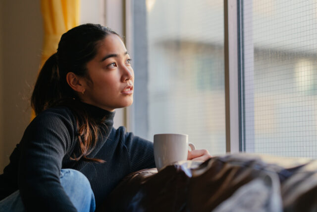 thoughtful woman looking out window