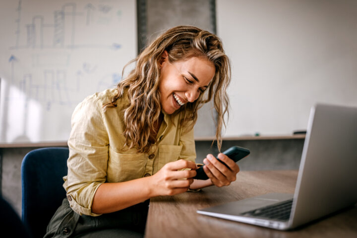 woman smiling while texting
