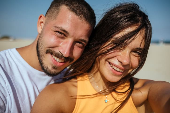 Happy couple selfie on the beach.