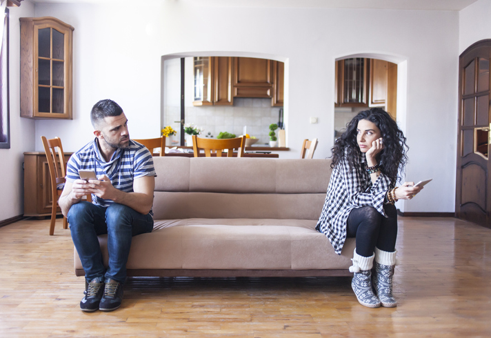 Unhappy couple sitting on couch.