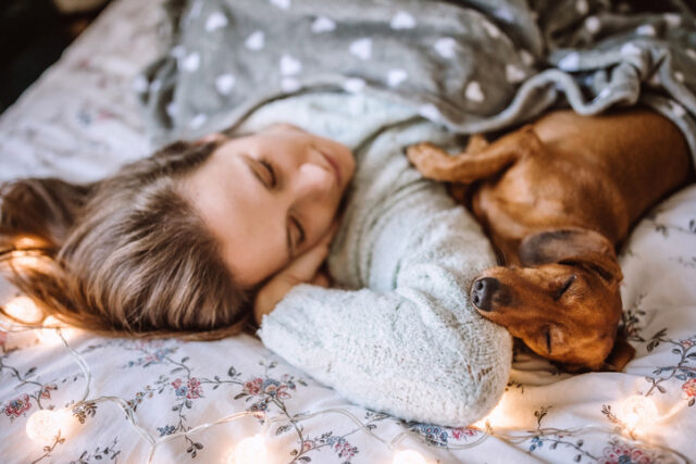 woman sleeping with her dog