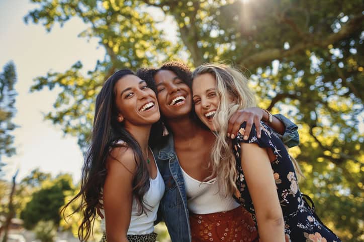 three friends smiling at park