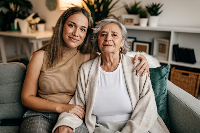 Woman on her couch with her grandmother.