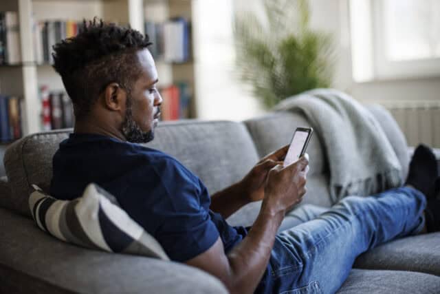 man texting on couch
